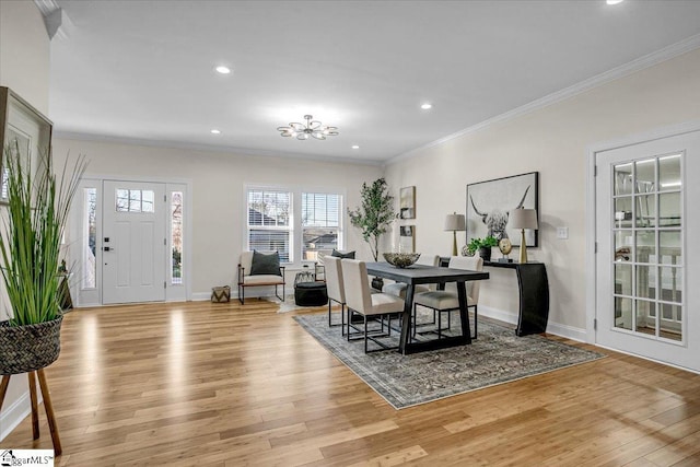 dining room with a notable chandelier, crown molding, baseboards, and wood finished floors