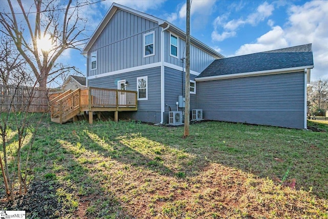 back of house featuring ac unit, a lawn, board and batten siding, and a wooden deck