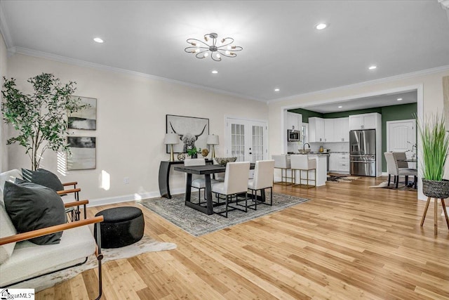 dining room featuring light wood-type flooring, french doors, a notable chandelier, and recessed lighting