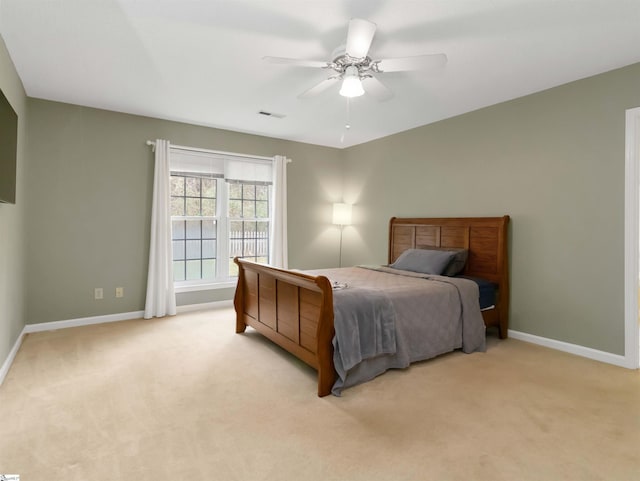 bedroom with visible vents, baseboards, light colored carpet, and a ceiling fan