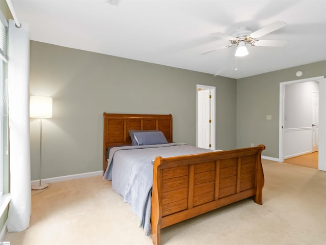 bedroom featuring a ceiling fan, baseboards, and light carpet