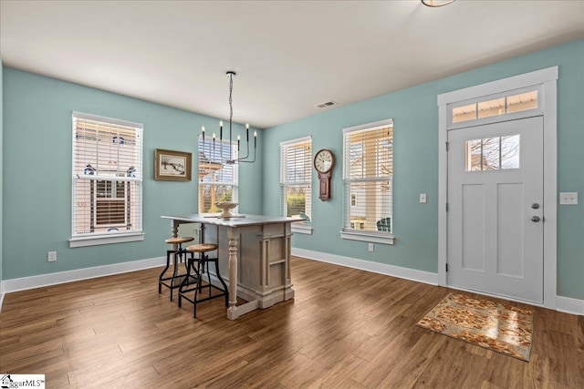 entryway featuring baseboards, dark wood-style floors, visible vents, and a chandelier