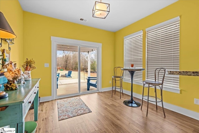 interior space with visible vents, baseboards, and wood finished floors