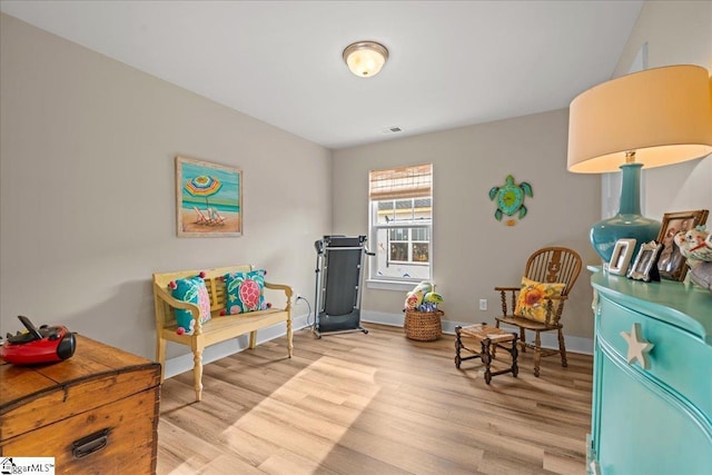 sitting room featuring visible vents, baseboards, and light wood-style floors