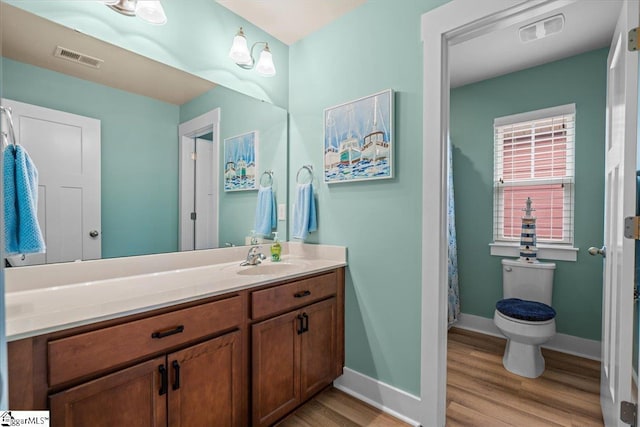 full bathroom featuring visible vents, vanity, baseboards, and wood finished floors