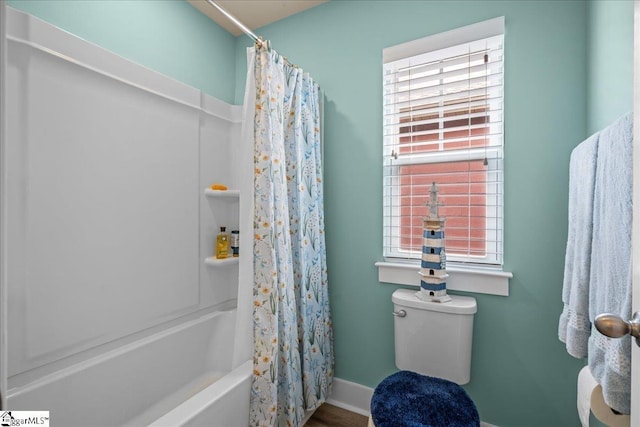 full bathroom featuring toilet, baseboards, and shower / tub combo with curtain