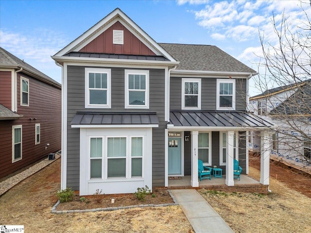 view of front facade featuring a standing seam roof, a porch, board and batten siding, a shingled roof, and metal roof