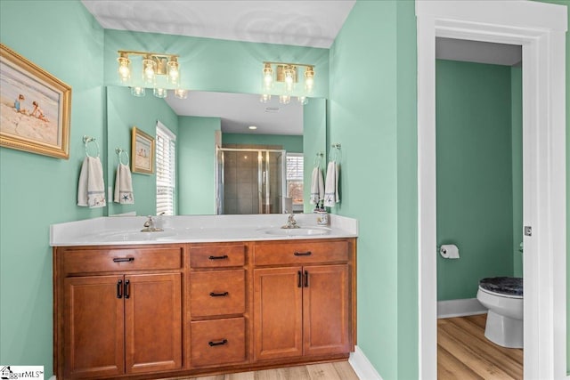 full bathroom featuring a shower stall, toilet, baseboards, and a sink