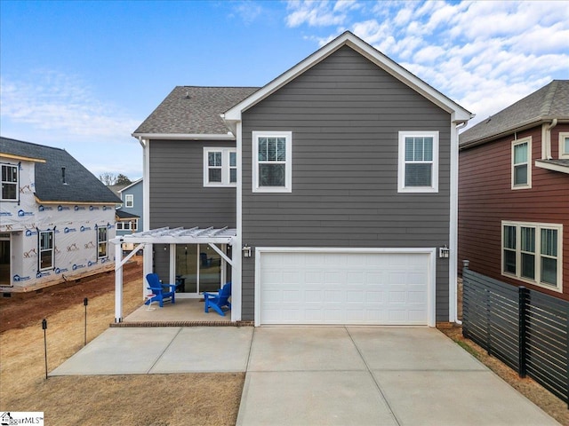 back of property with a patio area, driveway, a garage, and fence