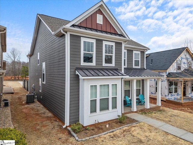 view of front of house featuring a standing seam roof, a patio, board and batten siding, a shingled roof, and metal roof