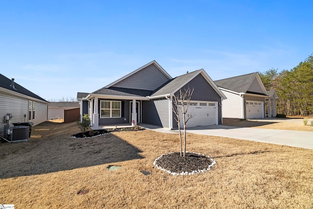 view of front of house with a front lawn, driveway, central AC, roof with shingles, and a garage