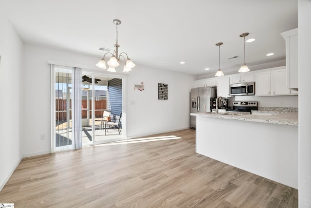 kitchen with visible vents, light wood-style floors, appliances with stainless steel finishes, white cabinetry, and a notable chandelier