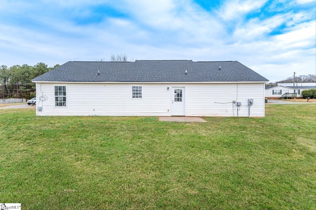 rear view of property featuring a lawn