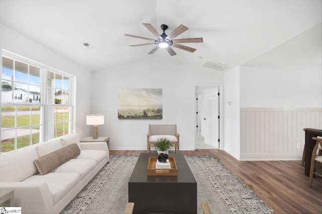 living room featuring vaulted ceiling, visible vents, ceiling fan, and wood finished floors