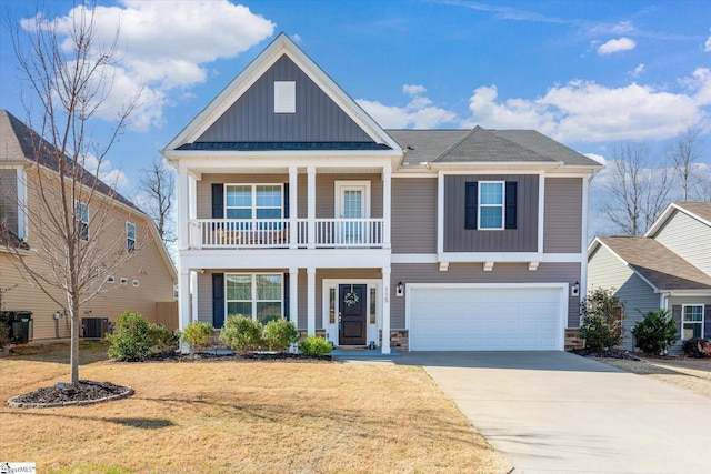 view of front of house featuring a front lawn, cooling unit, board and batten siding, concrete driveway, and an attached garage