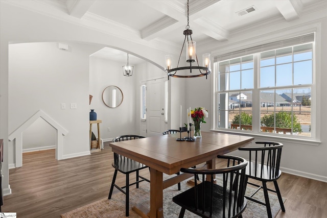 dining room with visible vents, beam ceiling, wood finished floors, arched walkways, and a notable chandelier