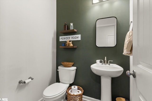 bathroom with baseboards and toilet