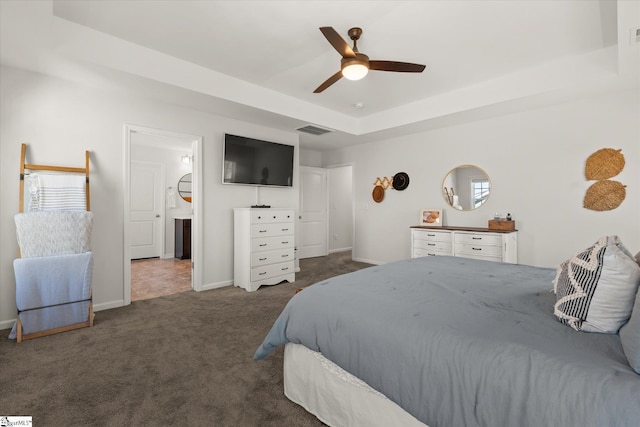 bedroom with visible vents, baseboards, carpet, a raised ceiling, and a ceiling fan