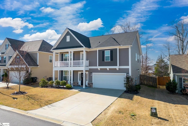 view of front of house with board and batten siding, a front lawn, fence, concrete driveway, and an attached garage