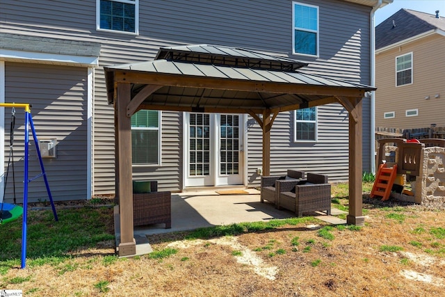 rear view of property featuring an outdoor living space, a gazebo, metal roof, a patio area, and a standing seam roof