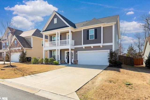 view of front of property with a front yard, fence, concrete driveway, a garage, and board and batten siding