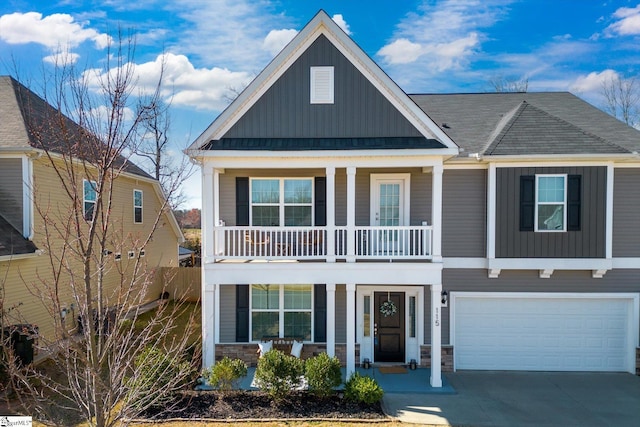 view of front of house with an attached garage, covered porch, concrete driveway, stone siding, and board and batten siding