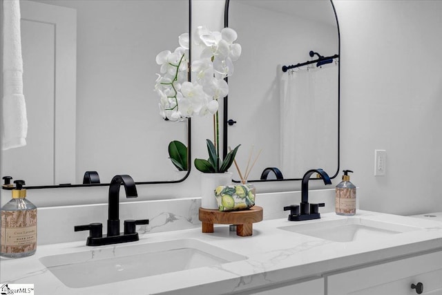 room details featuring double vanity, a shower with curtain, and a sink