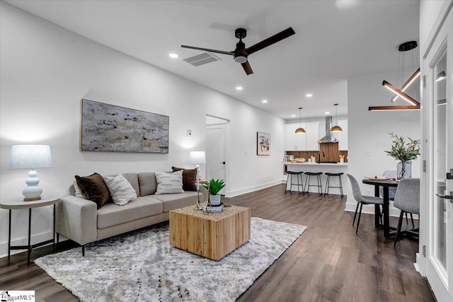 living area with visible vents, dark wood-type flooring, recessed lighting, baseboards, and ceiling fan