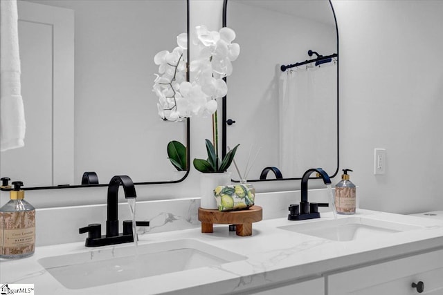 interior details with a sink, curtained shower, and double vanity