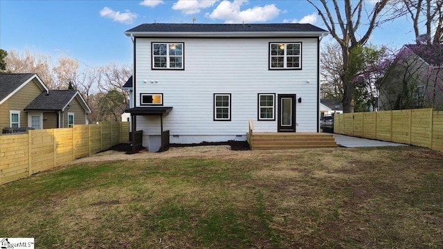 rear view of property featuring a yard and a fenced backyard