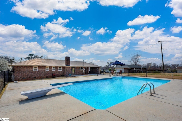 view of swimming pool featuring a patio, a diving board, fence, and a fenced in pool