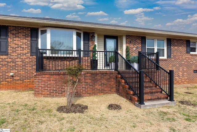 single story home featuring brick siding and a front lawn