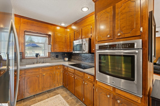 kitchen with a sink, decorative backsplash, brown cabinets, and stainless steel appliances