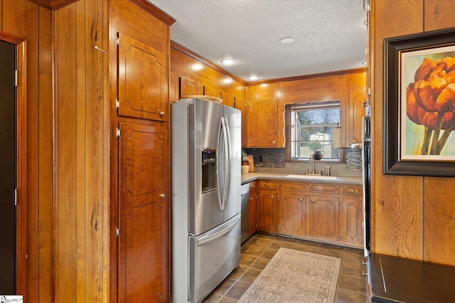 kitchen with brown cabinets, a sink, backsplash, stainless steel appliances, and light countertops