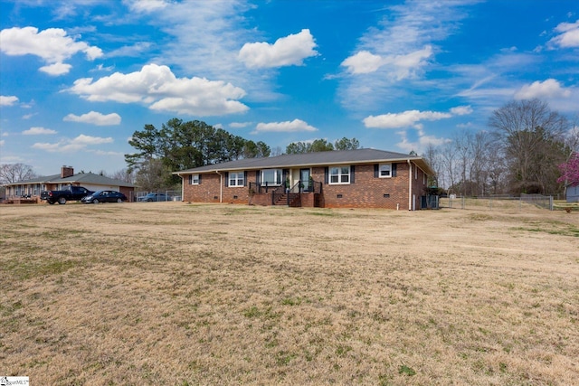 ranch-style home with a front yard, fence, brick siding, and crawl space