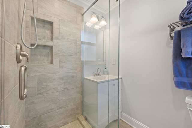 full bathroom with vanity, baseboards, a tile shower, ornamental molding, and toilet