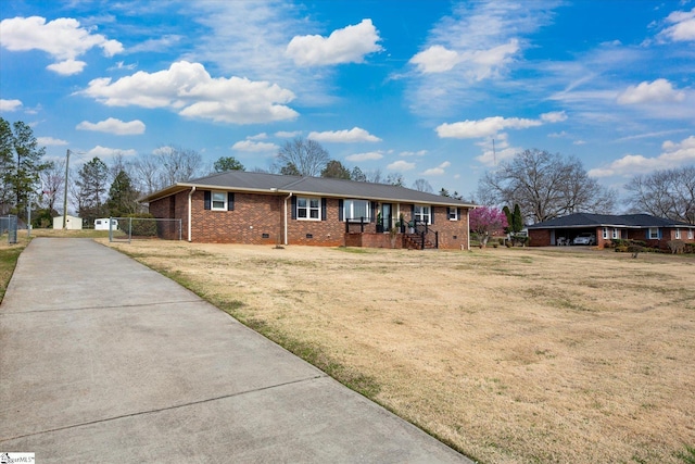 ranch-style home featuring crawl space, driveway, brick siding, and a front lawn