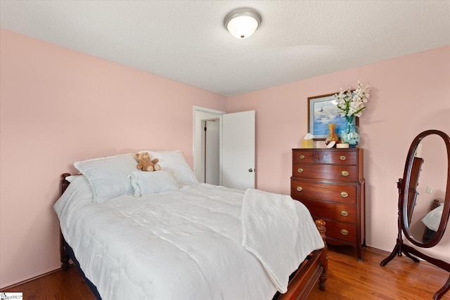 bedroom featuring a textured ceiling and wood finished floors