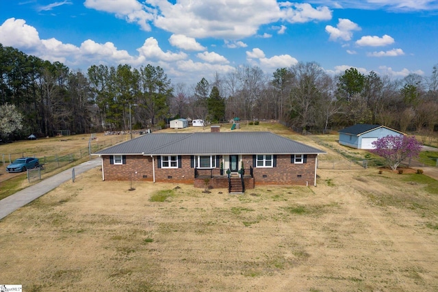 ranch-style house featuring crawl space, brick siding, metal roof, and fence