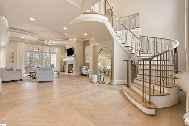 staircase featuring crown molding, recessed lighting, arched walkways, and baseboards