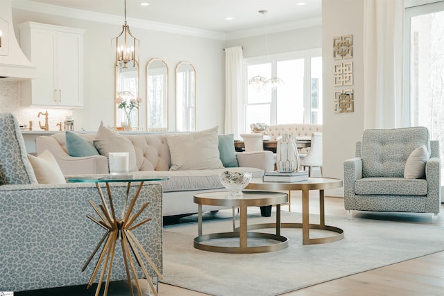 living area featuring an inviting chandelier, recessed lighting, light wood-type flooring, and ornamental molding