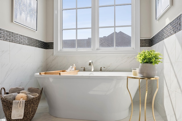 full bathroom with tile walls and a freestanding tub