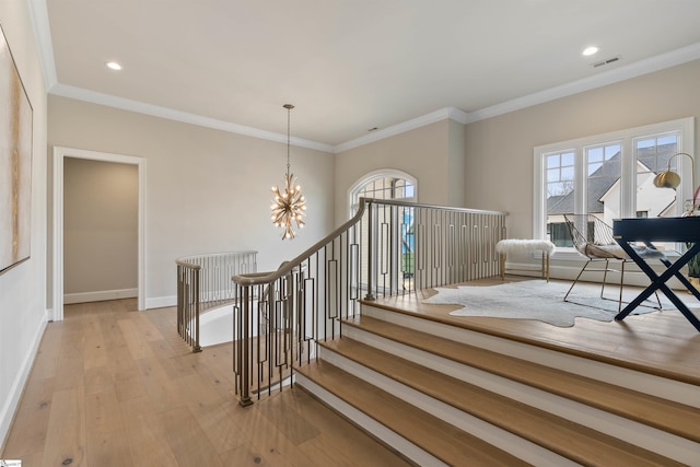 stairs with hardwood / wood-style floors, a notable chandelier, a healthy amount of sunlight, and baseboards