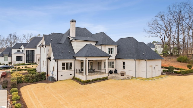 back of house featuring a patio, a residential view, roof with shingles, and a chimney