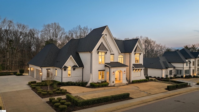 view of front of property with concrete driveway, an attached garage, and brick siding