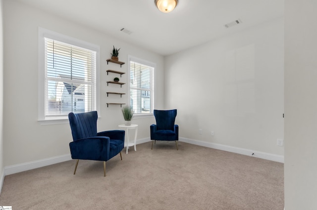 living area featuring visible vents, baseboards, and carpet