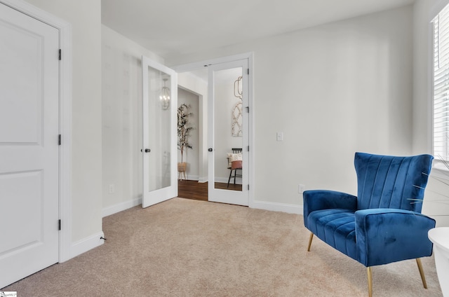 living area with french doors, plenty of natural light, carpet, and baseboards