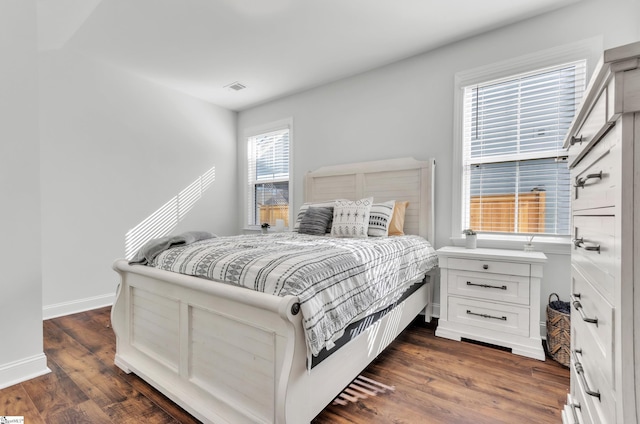 bedroom featuring visible vents, baseboards, and dark wood-style flooring