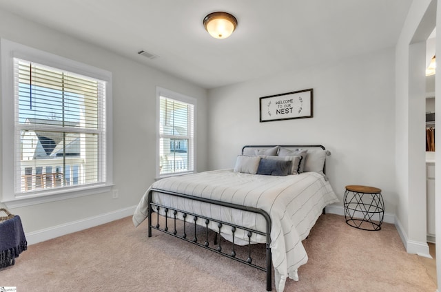 carpeted bedroom featuring visible vents and baseboards