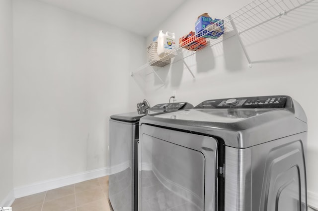 laundry room featuring laundry area, light tile patterned floors, baseboards, and independent washer and dryer